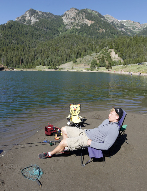 Al Hartmann  |  The Salt Lake Tribune
Nick Olson of Salt Lake City relaxes with a fishing line in the water at Tibble Fork Reservoir in American Fork Canyon Friday June 21, 2013. He said that he doesn't really care if he catches a fish. He's up there for the clean air with his family. "This is where I get my peace," he said. The U.S. Forest Service is overhauling its recreational fee program for American Fork Canyon and Mirror Lake Scenic Byway. Instead of charging everyone who drives into these areas, the Forest Service proposes charging only those who use the recreational amenities.