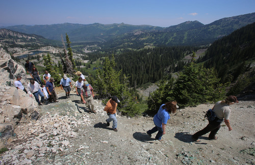 Francisco Kjolseth  |  The Salt Lake Tribune
Big Cottonwood Canyon stretches out in the background (that's Lake Mary in the upper left) as state, federal and Great Western Mining Co. officials walk along a ridge overlooking Brighton Resort. The company wanted land managers to see the central Wasatch Mountain property it would like to sell through a third party, which would make it part of the public domain.