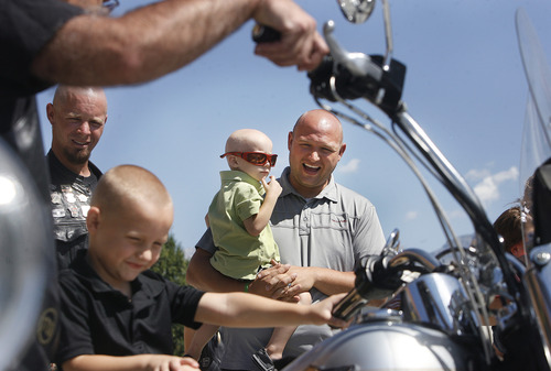 Scott Sommerdorf  |  The Salt Lake Tribune
Two-year-old Derek Fugal, of Springville, being held by his father, Jay Fugal, watches as big brother Tyler, 4, sits on Aaron Aldridge's Harley-Davidson Heritage Soft Tail motorcycle. The ride from Black Ball Performance in Lindon to Legends Motorcycle in Springville, Sunday, July 14, 2013 was to benefit Derek, who is battling kidney cancer.