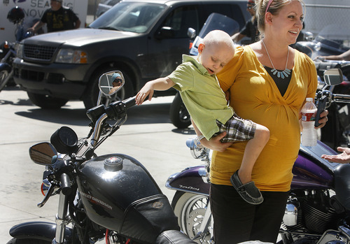 Scott Sommerdorf  |  The Salt Lake Tribune
Kara Fugal holds 2-year-old Derek Fugal as he plays with the throttle on Kimberly Brimhall's motorcycle Sunday. The ride from Black Ball Performance in Lindon to Legends Motorcycle in Springville, Sunday, July 14, 2013 was to benefit Derek, who is battling kidney cancer.