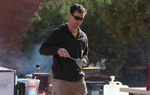Francisco Kjolseth  |  The Salt Lake Tribune
Matt Bedke of Vancouver, Canada, distributes a fresh-made batch of scrambled eggs to those with an open plate as everyone pitches in with the morning meal while camping in Arches National Park in late May.