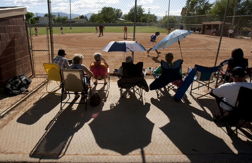 Steve Griffin | Tribune file photo
Fans block the sun with an umbrella as they watch little league baseball at the Riverton baseball fields near 12800 South and 1500 West in Riverton Tuesday June 25, 2013. On July 5, the city began demolishing the ball fields to the dismay of some residents.