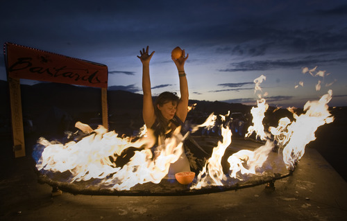 Rick Egan  | The Salt Lake Tribune 

Momo, bartender for Bat Country, serves drinks at a flaming bar, at the Element 11 Arts Festival at Bonneville Seabase, July 12, 2013.