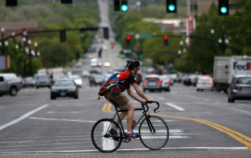 Francisco Kjolseth  |  The Salt Lake Tribune
A bicyclist peddles through Salt Lake City downtown traffic on April 30, 2012. Cyclists who violate the rules of the road can be cited.