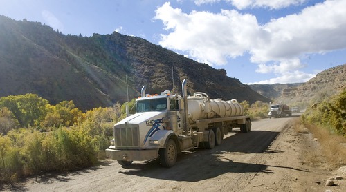 Al Hartmann  |  Tribune file photo  
Bill Barrett Corporation water trucks make their way along the dirt road in Nine Mile Canyon. Just above the road are hundreds of examples of rock art that can be impacted by the dust thrown up by the large trucks.