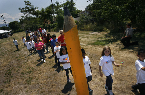 Scott Sommerdorf   |  The Salt Lake Tribune
Guadalupe School students march by a huge pencil as they move to form a human chain to delineate the new building's perimeter. This ties to the event's theme "Staking our Future: A New Building. A New Hope," Thursday, July 18, 2013.