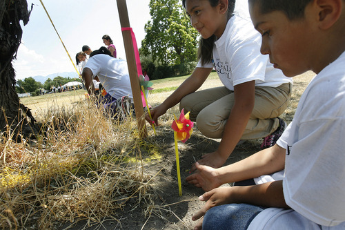 Scott Sommerdorf  |  The Salt Lake Tribune
Fourth grader Maritza Santana, center, and Felipe de la Torre who will be in first grade, plant their pinweels into the dirt on Thursday along the staked out perimiter that delineates the new building's perimeter. This ties to the event's theme "Staking our Future: A New Building. A New Hope."