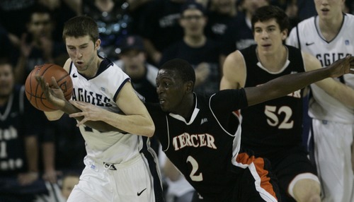 Kim Raff | The Salt Lake Tribune
Utah State University Preston Medlin tries to hang onto the ball as Mercer player Travis Smith reaches for it during the CIT Championship game at Utah State University in Logan, Utah on March 28, 2012.  Mercer went on to win the game 67-70.