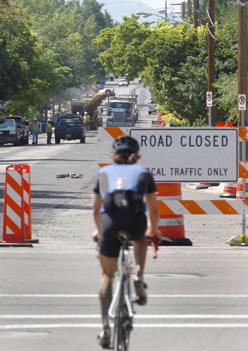 Al Hartmann  |  The Salt Lake Tribune
A bicyclist comes to road closed signs at 900 East and 1300 South Thursday July 18 as road crews strip asphalt a block to the south. The city is reconstructing part of 900 East south of 1300 South, removing old railroad ties that have been buried for decades. The city rebuilt the same street four years ago and residents are unhappy the city is tearing up the street again so soon.