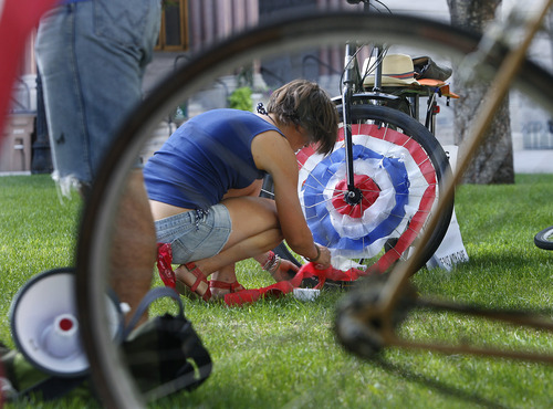 Scott Sommerdorf   |  The Salt Lake Tribune
Heidi Goedhart decorates her bike wheel with red white and blue crepe paper prior to their July ride with the theme "MERICA" in Salt Lake City, Saturday, July 13, 2013.