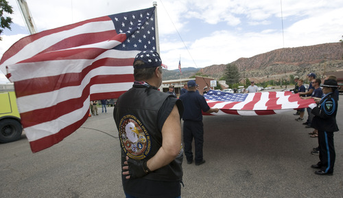 Rick Egan  |  The Salt Lake Tribune 
Members of the Patriot Guard Riders hold flags as the Ogden Fire Department prepared to raise a giant American flag at the benefit picnic for Joe Thurston at Cedar City Park on Main Street, Saturday, July 20, 2013. The event is to honor and raise money for Thurston, a Cedar City native and Hotshot firefighter who died in the Arizona wildfire last month.
