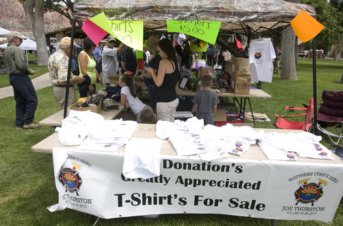 Rick Egan  |  The Salt Lake Tribune 
T-Shirts and raffle tickets are sold at the benefit picnic for Joe Thurston at Cedar City Park on Main Street, Saturday, July 20, 2013. The event is to honor and raise money for Thurston, a Cedar City native and firefighter who died in the Arizona wildfire last month.