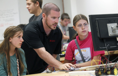 Al Hartmann  |  The Salt Lake Tribune
Maxine Erickson, 13, left, and lab partner Chloe Josien, 15, right, get help coding computers from instructor Sam Wright at the University of Utah Computer Science GREAT camp. The camp fills what are now voids in most Utah schools: advanced computer programming, robotics and graphics. This summer, it hosts about 500 students and is backed in part by software companies Microsoft and Nvidia.