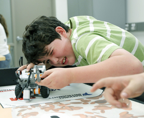 Al Hartmann  |  The Salt Lake Tribune
Gray Fitzpatrick, 9, eyes up his programmable robot in June at computer science camp at the University of Utah. Teachers and computer professionals liken computer science to a learning a language. They say that to date, students are required to make the equivalent of small talk, but they should be trained to speak fluently, and that means learning to program computers.