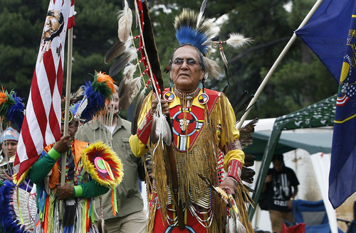 Scott Sommerdorf   |  The Salt Lake Tribune
David Yazzie Jr. leads the opening procession and grand entry of dancers into the ring at the Native American celebration in the Park - the annual Pioneer Day event celebrating American Indian culture, Wednesday, July 24, 2013.