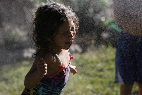 Francisco Kjolseth  |  The Salt Lake Tribune
Alisha Auger, 4, squeals in delight as she cools off in a mister as Rose Park neighbors come together for a neighborhood barbecue along Lafayette Drive recently to enjoy each other's company.