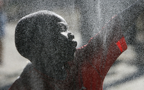 Francisco Kjolseth  |  The Salt Lake Tribune
Roi Ngoida, 6, of Cameroon cools off in the spray of a mister as he and other residents of Rose Park come together for a neighborhood barbecue along Lafayette Drive recently to enjoy each other's company.