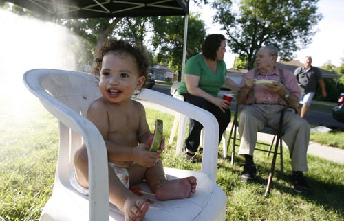 Francisco Kjolseth  |  The Salt Lake Tribune
Markayla Auger, 15 months, enjoys a piece of watermelon during a neighborhood party being hosted by Heather Hans, in background, meeting with her neighbor George Jackson who has lived in the same home since 1951.