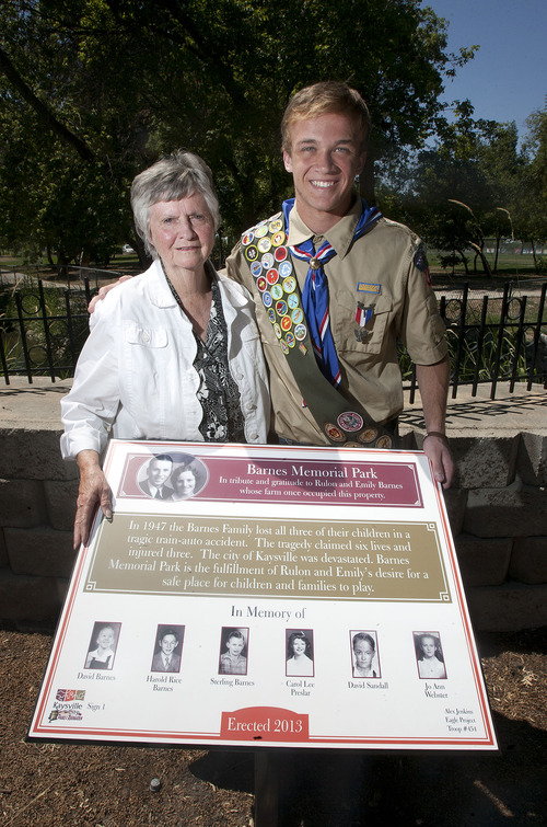Steve Griffin  |  The Salt Lake Tribune
Chloe Thompson and Alex Jenkins, 15, stand with a sign at Kaysville's Barnes Park, paid for with money Jenkins raised as part of his Eagle Scout project that memorializes a tragedy that led to the park's creation. The sign was placed in the Kaysville park on July 17, 2013. Thompson is a niece of Rulon and Emily Barnes, who lost their three sons in a 1947 car-train accident that also killed three other children. They donated land for Barnes Park to create a place where children could play safely.
