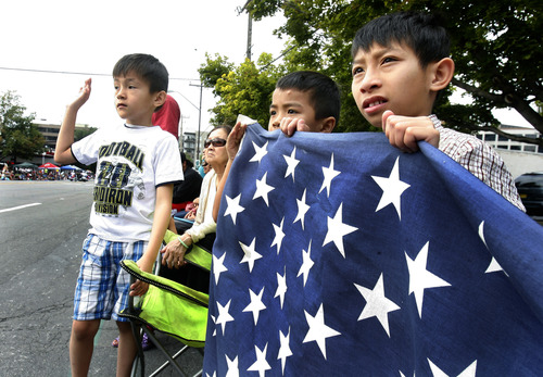 Scott Sommerdorf   |  The Salt Lake Tribune
Alex, left, Collins, center, and Bill Nguyen watch the Pioneer Day Parade, Wednesday, July 24, 2013.