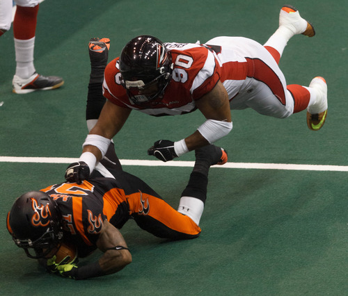 Trent Nelson  |  The Salt Lake Tribune
Utah's LaVaughn Macon is brought down by Cleveland's Darren Branch as the Utah Blaze face the Cleveland Gladiators, AFL football at EnergySolutions Arena in Salt Lake City, Saturday July 27, 2013.