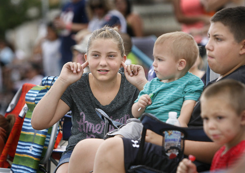 Scott Sommerdorf   |  The Salt Lake Tribune
Ali Rasmussen plugs her ears as a float with revving race cars goes by during the International Days Parade in Price on July 27, 2013.  Josh Rasmussen holds 2-year-old Cooper Pace to the right.