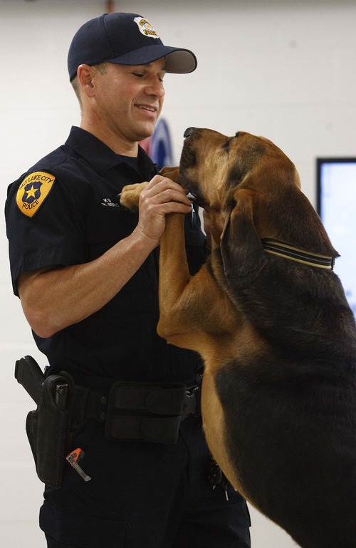 Leah Hogsten  |  The Salt Lake Tribune
Salt Lake Police K-9 handler Mike Serio and his 4-year-old Bloodhound "Junior" educate visitors at the new Public Safety Building on the job descriptions of the seven dogs the police department uses Friday, July 26, 2013. "Bloodhound in Blue: The True Tales of Police Dog JJ and His Two-Legged Partner" by author Adam David Russ chronicles the adventures of Salt Lake Police K-9 handler Mike Serio and his former police bloodhound JJ, who helped catch 271 criminals in his career, even as he battled cancer.