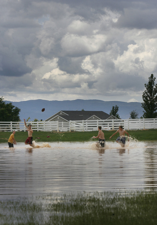 Scott Sommerdorf   |  The Salt Lake Tribune
Even as the next storm approaches, boys play football in the flooded baseball field in the Equestrian Pointe neighborhood of west Cedar City, Sunday, July 28, 2013.