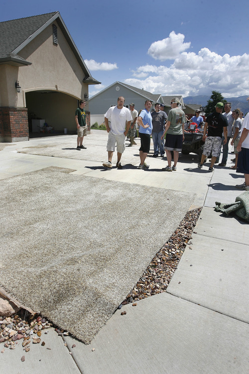 Scott Sommerdorf   |  The Salt Lake Tribune
Volunteers from the Cedar City 11th Ward meet near carpets pulled out of the home, to discuss their next move after working to save the home of a family that was out of town when the storm hit. The home is in the Equestrian Pointe neighborhood of west Cedar City, Sunday, July 28, 2013.