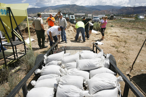 Scott Sommerdorf   |  The Salt Lake Tribune
Volunteers work to make sandbags for hard hit neighborhoods at the Iron County Search and Rescue center in Cedar City, Sunday, July 28, 2013.
