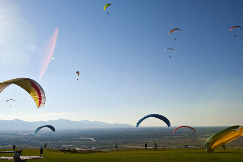 Chris Detrick  |  The Salt Lake Tribune
With pollution visible in the background, paragliders fly over Point of the Mountain Flight Park at Steep Mountain near Geneva Rock Products in Draper Friday July 19, 2013.