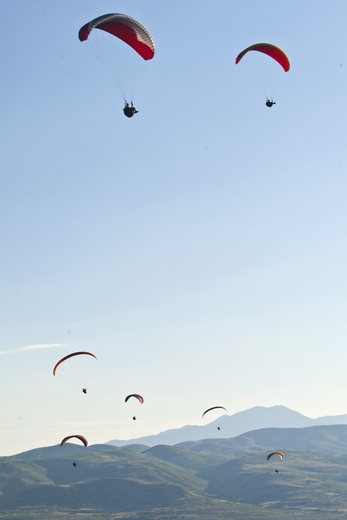 Chris Detrick  |  The Salt Lake Tribune
With pollution visible in the background, paragliders fly over Point of the Mountain Flight Park at Steep Mountain near Geneva Rock Products in Draper Friday July 19, 2013.