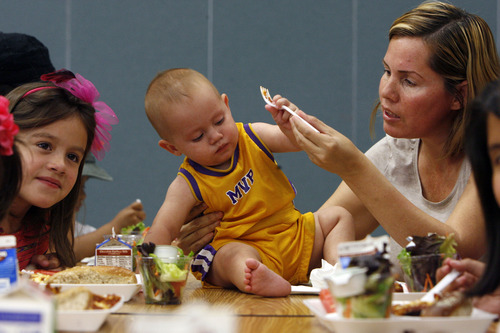 Francisco Kjolseth  |  The Salt Lake Tribune
Alma Pinto feeds her son Sebastian Valdivia, 10 months, at Timpanogos Elementary School in Provo on Thursday, July 11, 2013. In Provo schools, rosemary chicken with buerre blanc, fresh thyme and parsley frequents the school year menu.