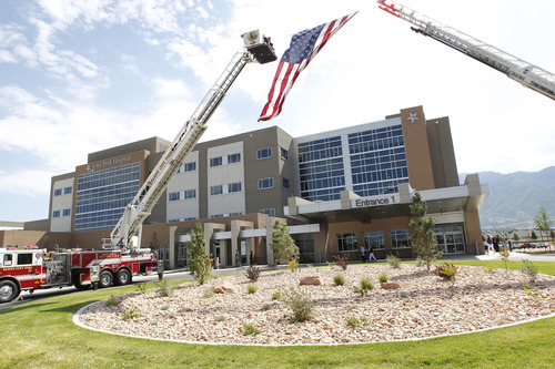 Al Hartmann  |  The Salt Lake Tribune
Draper Fire Department's ladder trucks form an arch with American flag for the opening of the Lone Peak Hospital at 11925 S. State St. Tuesday July 30.