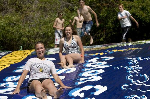 Kim Raff  |  The Salt Lake Tribune
(from left) Kelsey Johnson, Cameron Egan and Ethan Russell slide down a make shift slip and slide while hanging out with friends from Mount Ogden Junior High and celebrating their last day of school at Mount Ogden Park in Ogden on May 24, 2013.
