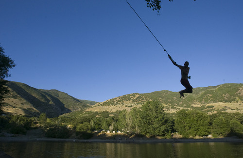 Rick Egan  | The Salt Lake Tribune 

Sixteen -year-old Spencer Black jumps into  Farmington Pond from a rope swing, Wednesday, July 31, 2013.