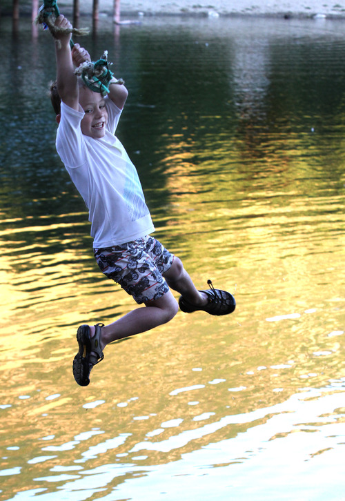 Rick Egan  | The Salt Lake Tribune 

Will Vanderlinden, Bountiful, swings on a rope swing, at Farmington Pond, Wednesday, July 31, 2013.