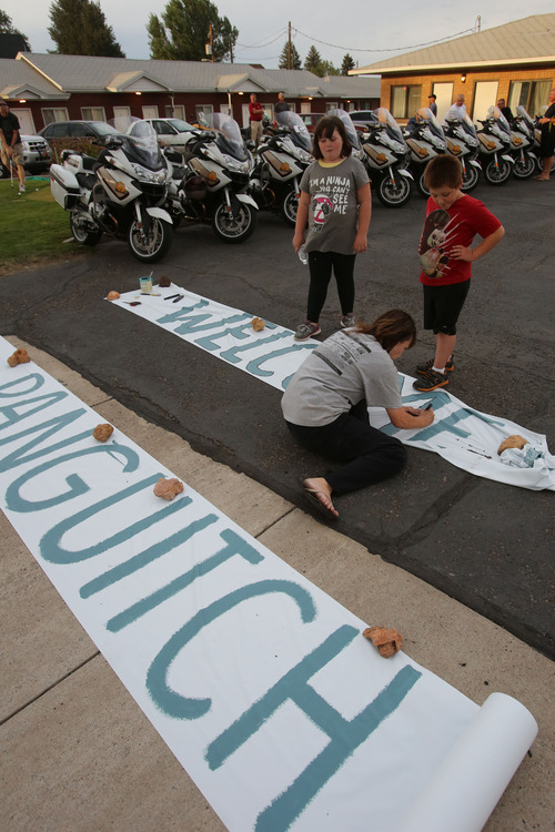 Francisco Kjolseth  |  The Salt Lake Tribune
Cheryl Church director of Panguitch Main Street is helped by Cheyanne Branin, 9, and Trampas Gilbert, 7, as they ready banners to welcome the Tour of Utah for stage two starting in Panguitch on Wednesday.