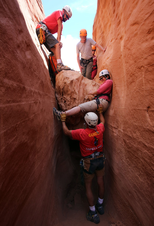 Francisco Kjolseth  |  The Salt Lake Tribune
Nancy Green gets a helping hand from guide Rick Green as she bridges the gap during a descent down a slot canyon in southern Utah.