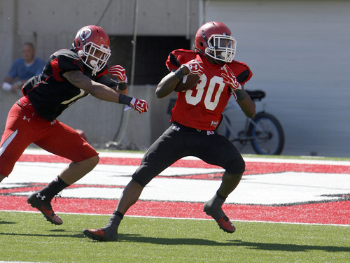Francisco Kjolseth  |  The Salt Lake Tribune
Dre'Vian Young puts in an impressive run towards a touchdown as he moves past Keith McGill as the University of Utah's football team holds their first preseason scrimmage at the stadium on Tuesday, August 13, 2013.