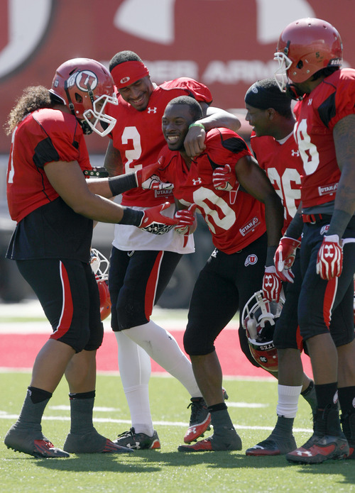 Francisco Kjolseth  |  The Salt Lake Tribune
Dre'Vian Young is celebrated by teammates after putting in an impressive run as the University of Utah's football team holds their first preseason scrimmage at the stadium on Tuesday, August 13, 2013.