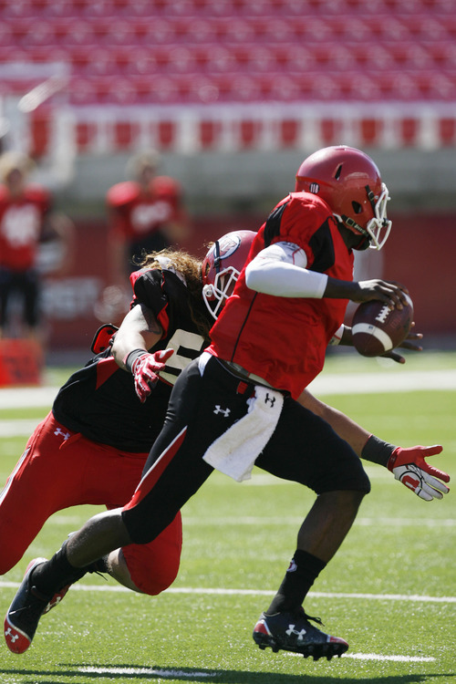 Francisco Kjolseth  |  The Salt Lake Tribune
Quarter back Micah Thomas tries to stay ahead of the defense as the University of Utah's football team holds their first preseason scrimmage at the stadium on Tuesday, August 13, 2013.