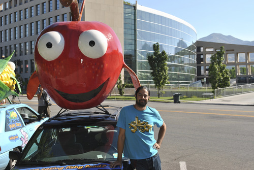 Matthew Piper  |  The Salt Lake Tribune
On Tuesday in Library Square, Nikolas Schiller sits besides Goldie the apple, which he is driving 3,300 miles across the country to raise awareness of GMO foods.
