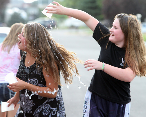Rick Egan  | The Salt Lake Tribune 

Julianne Orton, 15, laughs as Kylee Salazar  tosses water on her, during a water fight after gathering vegetables from the Community Garden, with the West Point Youth Council on Aug. 7, 2013. Orton attends an online charter school, which allows her to arise later on school mornings than do her peers in traditional schools.