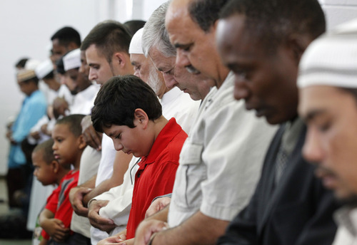 Al Hartmann  |  The Salt Lake Tribune
Utah Muslim fathers and sons pray at the Khadeeja Islamic Center in West Valley City on Thursday, Aug. 8, to celebrate the end of their monthlong fast for Ramadan.