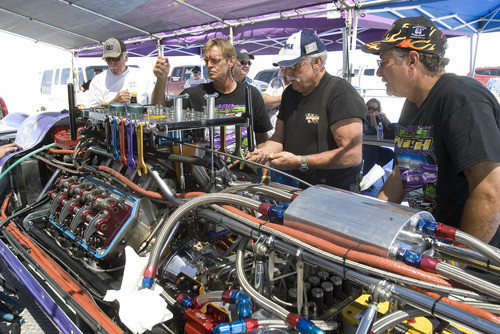 Paul Fraughton  |   Salt Lake Tribune
   Mike Nish,third from right, who pilotsThe Royal Purple   works with team members on  the car  after its morning run on the Bonneville Salt Flats.                         
 Tuesday, August 13, 2013