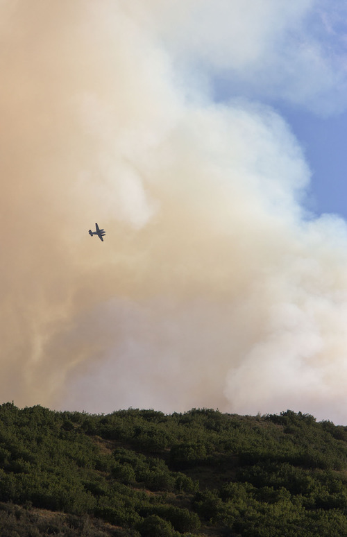 Lennie Mahler  |  The Salt Lake Tribune
A plane hovers over a wildfire near Rockport State Park as crews work to control the blaze Tuesday, Aug. 13, 2013.