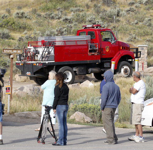Al Hartmann  |  The Salt Lake Tribune
Residents watch as firefighting trucks turn off SR 32 to head up the mountain to the burned area of Rockport Estates subdivision Wednesday morning August 14. The mountainside and several homes burned from Tuesday's Rockport fire.