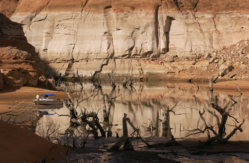 Trent Nelson  |  Tribune file photo
Morris Christensen stands next to his boat on a sandbar in Forgotten Canyon exposed by the low water level in Lake Powell in 2003. Low flows on the Colorado River have forced water authorities to take the historic step of reducing the outflow of water from Glen Canyon Dam, which forms Lake Powell, creating great concern among downstream users such as Las Vegas.