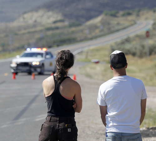Al Hartmann  |  The Salt Lake Tribune
Rockport Estates homeowners Tschana and Matt Schiller look at blackened mountainside and try to see their house from behind road block just outside Wanship Thursday August 15.  They saw their home through binoclulars and thought it looked intact but homeowners are still under an earlier evacuation order from going back to their homes due to the threat of the Rockport fire.